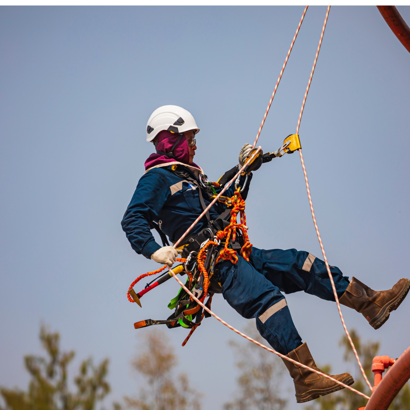 Rope access technician suspended with safety equipment