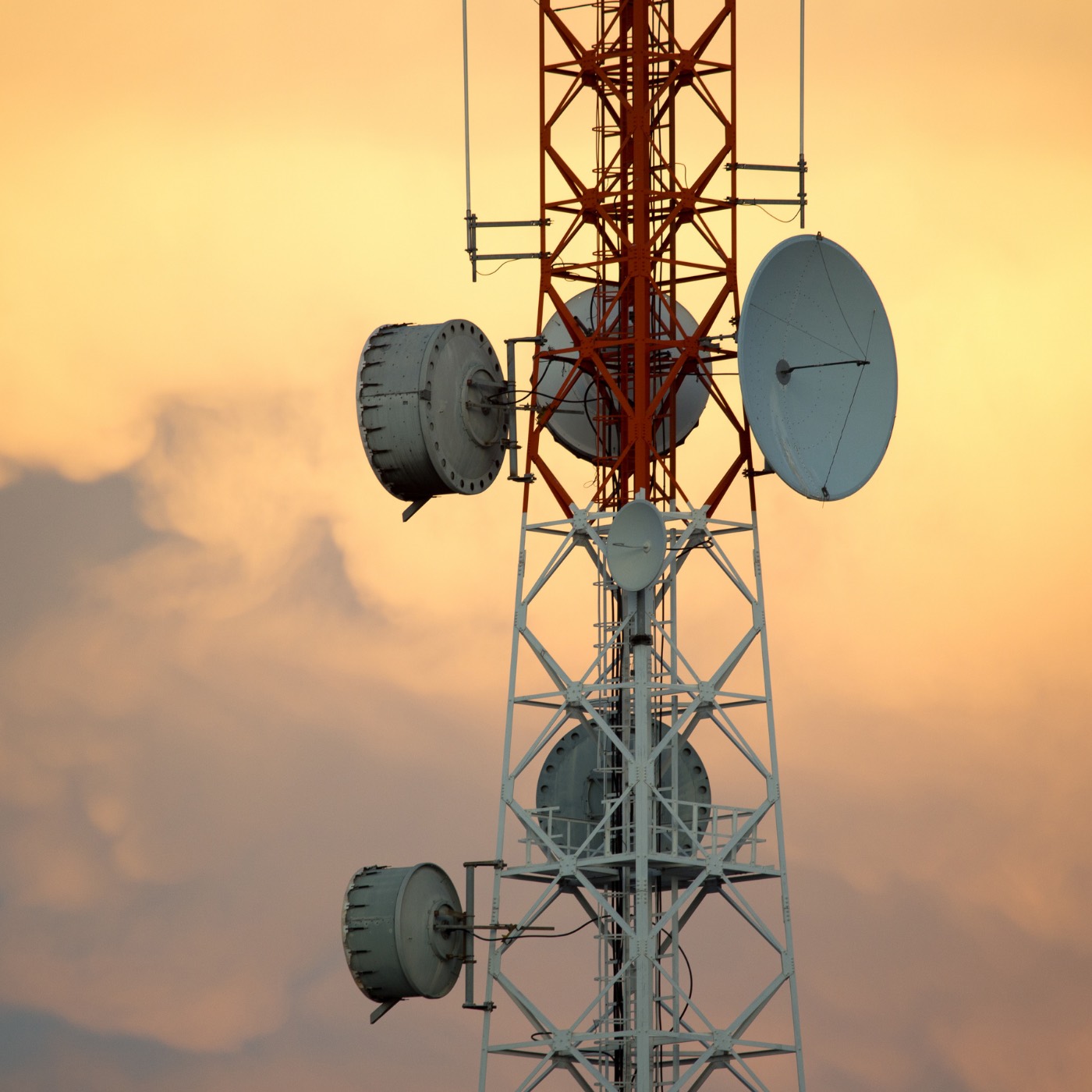 Telecommunications tower with antennas at sunset