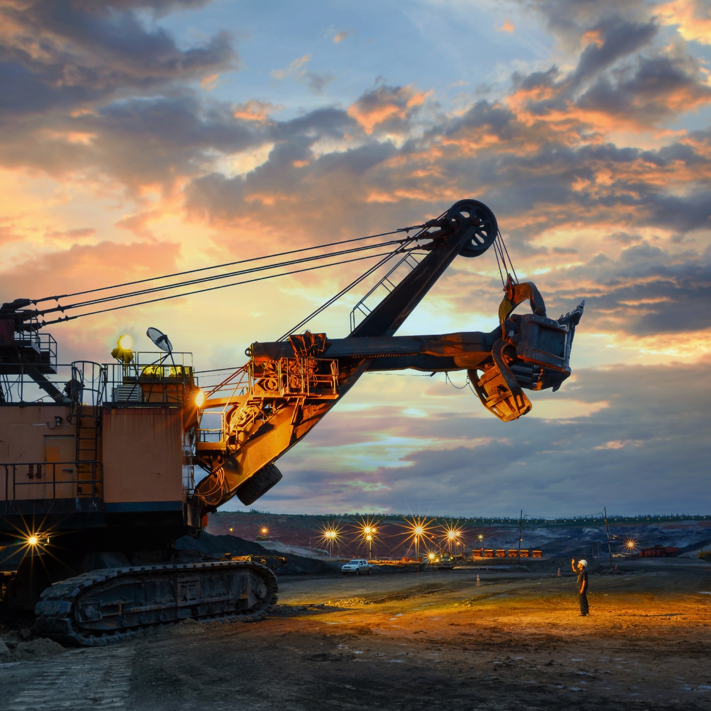 Large mining machinery working under dramatic light at an industrial site